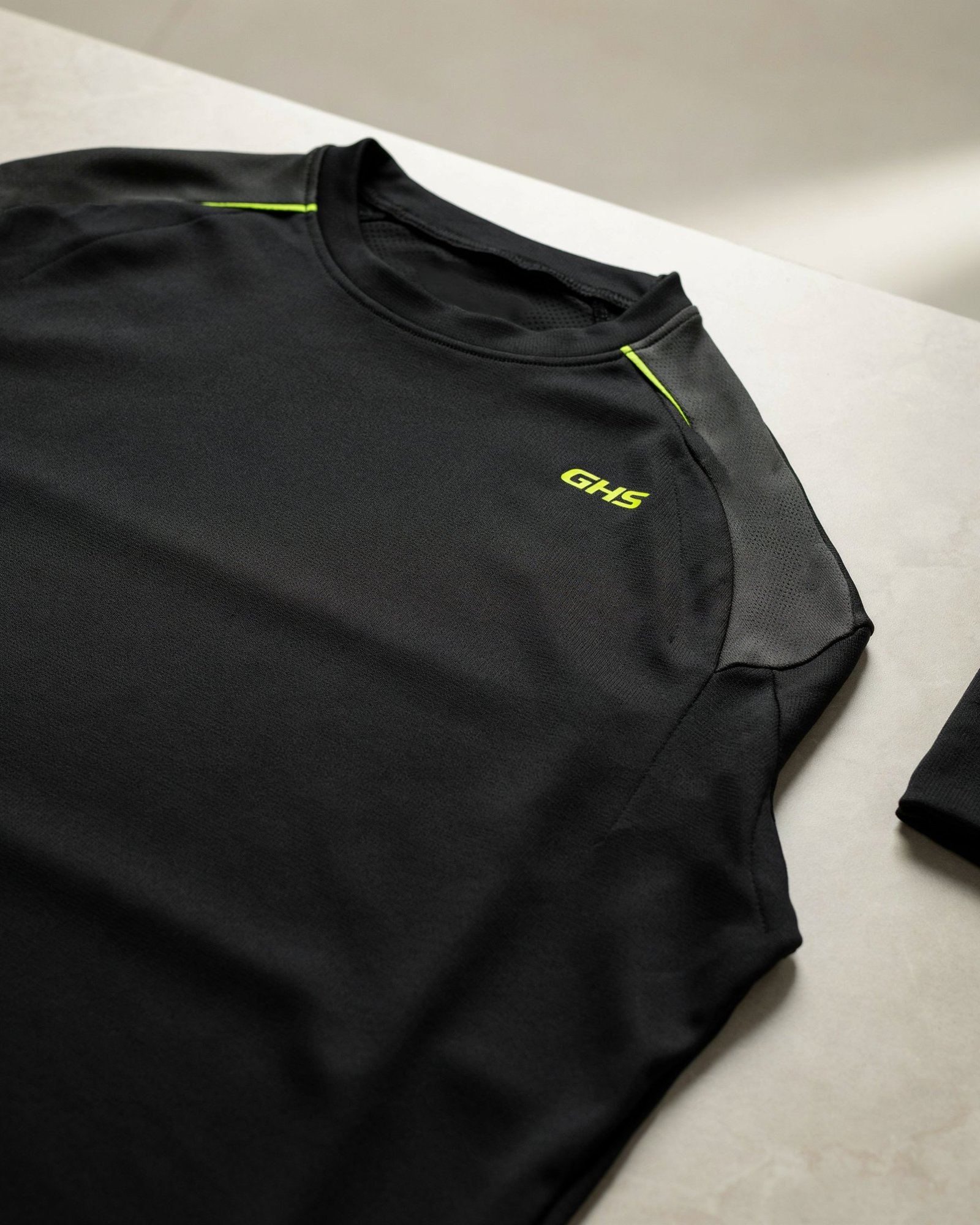 Close-up of GHS compression sportswear fabric showing technical stretch knit, ergonomic panels and flatlock seams